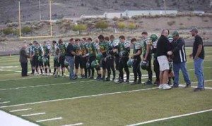 Courtesy photo The 2015 Eureka County High football team shakes hands with former coaches Grant Crutchley, Dennis Wells and Rod Garcia before the game against North Tahoe last Friday.