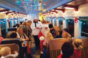 Santa Claus greets the train when it arrives at the North Pole and presents the children on board with a special gift.
